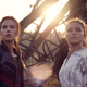 Natasha Romanoff and Yelena Belova, in their respective black and outfits, stand in front of metal wreckage.